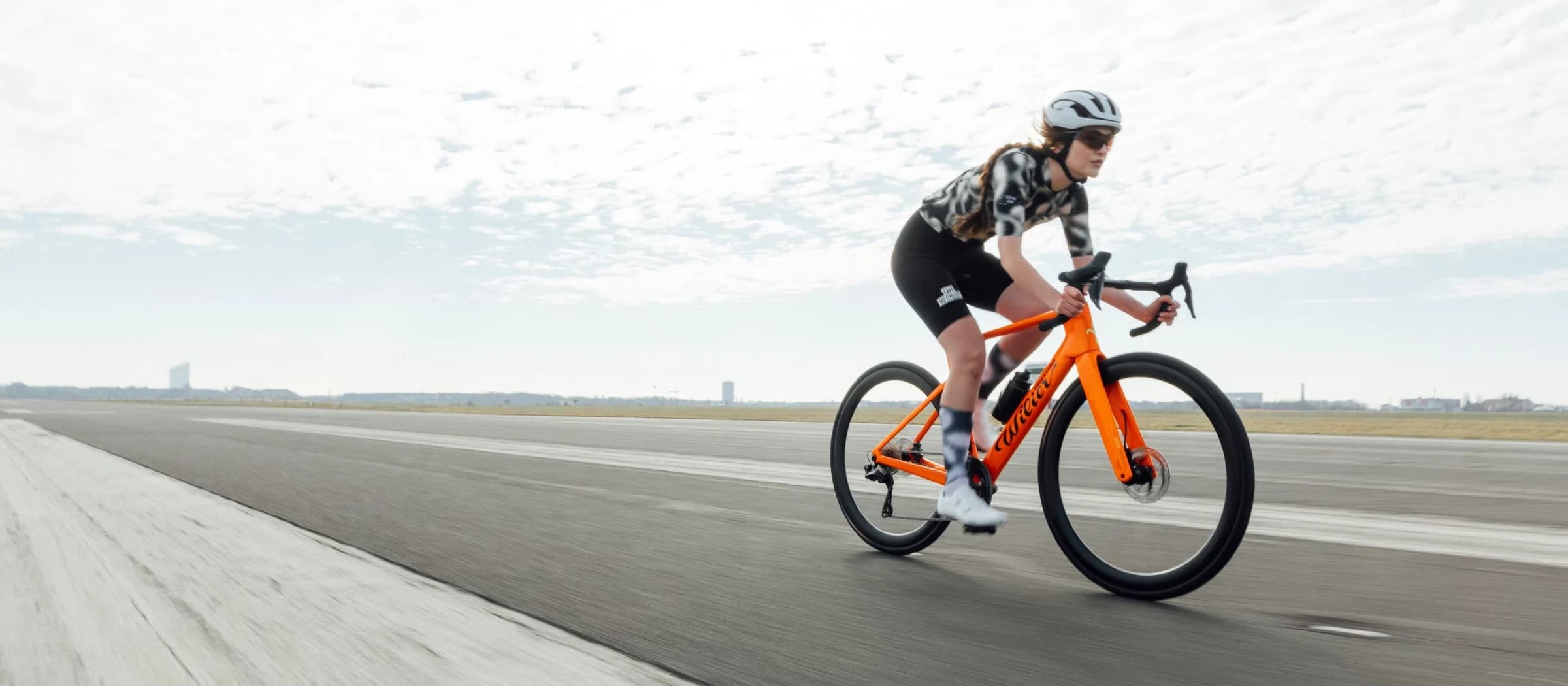 Ciclista rodando la Rapida en G48 Midday Orange sobre una pista despejada.