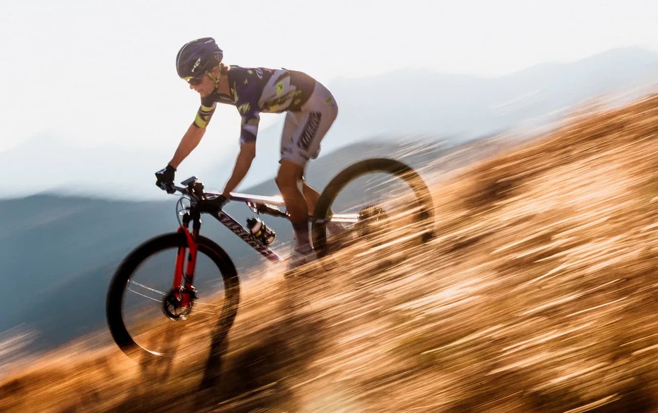 Ciclista de cross-country compitiendo cuesta abajo con la Urta Ultimate.